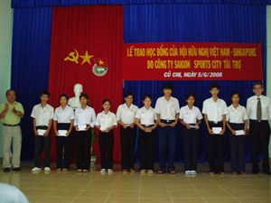 Tổng lãnh sự Vương quốc Singapore tại TP.HCM (bìa phải) trao học bổng cho các em học sinh
