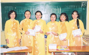 Hiệu trưởng (bìa trái) tặng giấy khen cho giáo viên