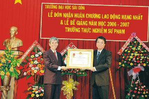 Thầy Nguyễn Tá Quốc - Hiệu trưởng nhà trường (trái) nhận Huân chương Lao động hạng Nhất