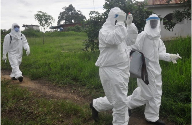 Nhân viên y tế ở ngoại ô thủ đô Monrovia rời đi sau khi lấy mẫu máu xét nghiệm Ebola - Ảnh: AP