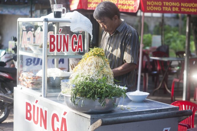 Quán bún cá đơn giản với rổ rau và bún bên cạnh nồi nước dùng - Ảnh: Minh Đức