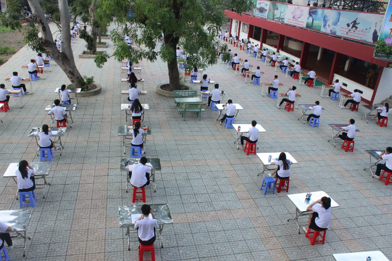 Học sinh Trường THPT An Dương Vương (TP.HCM) làm bài kiểm tra ở sân trường - Ảnh: từ Facebook của Trường THPT An Dương Vương
