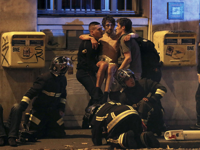 Cảnh sát Pháp đưa một nạn nhân bị thương khỏi nhà hát Bataclan, nơi bị bọn khủng bố tấn công đêm 13-11 - Ảnh: Reuters