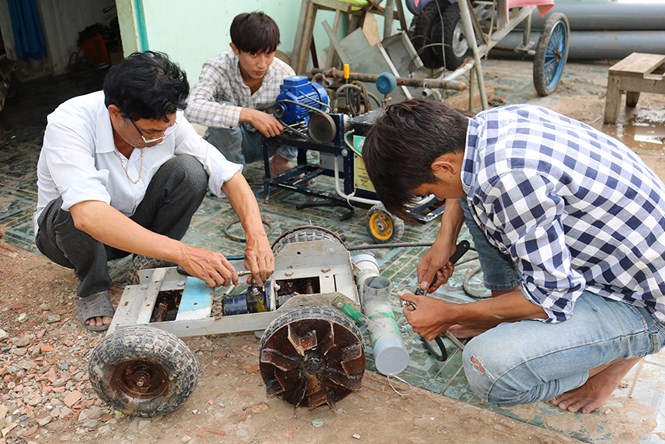 Anh Nguyễn Hoàng Nam (bìa trái) sản xuất robot thông cống /// Ảnh: Hữu Trãi