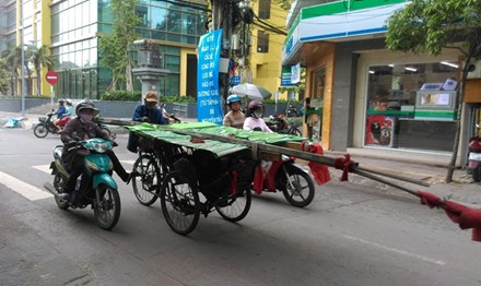 Nhiều xe thô  sơ, ba gác chở hàng cồng kềnh “đại náo” đường phố TPHCM. Ảnh: Văn Minh.