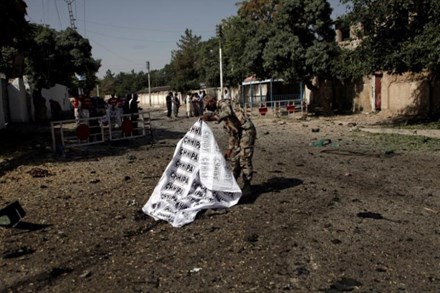 Một binh sĩ dùng bạt che thi thể nạn nhân trong vụ đánh bom ở Quetta. Ảnh: Reuters