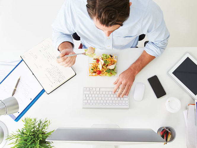Thói quen vừa ăn vừa làm việc là cách bắc cầu hữu hiệu cho vi khuẩn phi nhanh vào cơ thể  /// Ảnh: Shutterstock