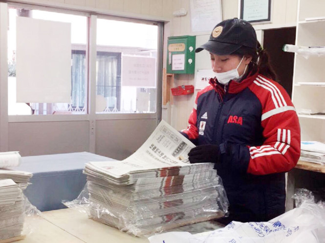 Nguyễn Thị Huệ lồng tờ quảng cáo vào báo và đi giao báo mỗi buổi sáng tại Nhật /// Ảnh: Cẩm Giang