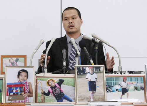 Anh Lê Anh Hào phát biểu bên các bức ảnh của bé Lê Thị Nhật Linh tại cuộc họp báo sau phiên xét xử đầu tiên ở Chiba hôm 4/6. Ảnh: Kyodo.