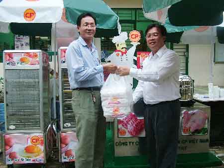 Giám đốc Công ty chăn nuôi PC Việt Nam (bên phải) trao quà cho Trường TH Lý Nhơn