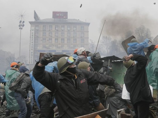 Anti-government protesters throw stones at riot police.