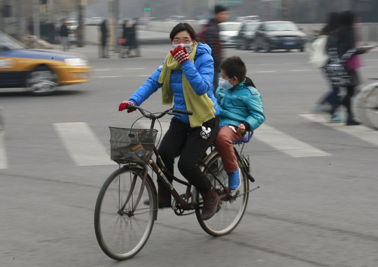 Người dân tại thủ đô Bắc Kinh - Trung Quốc đeo khẩu trang khi ra đường phố hôm 20-12 Ảnh: Reuters
