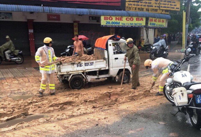 CSGT Tân Sơn Nhất đội mưa xúc, quét bùn cát ngập đường 