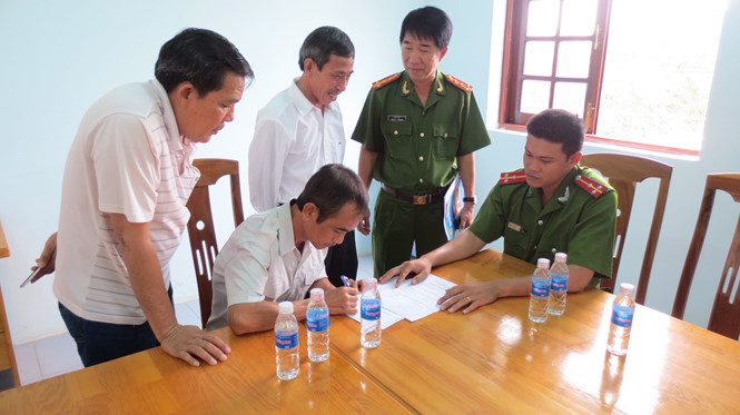 Ông Huỳnh Văn Nén ký vào biên bản bàn giao Quyết định đình chỉ bị can trước các cơ quan chức năng /// Ảnh: Quế Hà