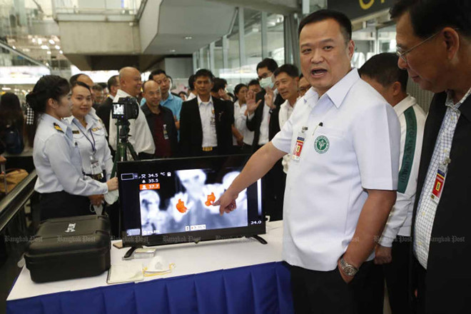 Bộ trưởng Y tế Thái Lan Charnvirakul (áo trắng) chỉ máy đo thân nhiệt đối với du khách đến từ Vũ Hán được lắp ở sân bay Suvarnabhumi ở Bangkok  /// Chụp màn hình Bangkok Post