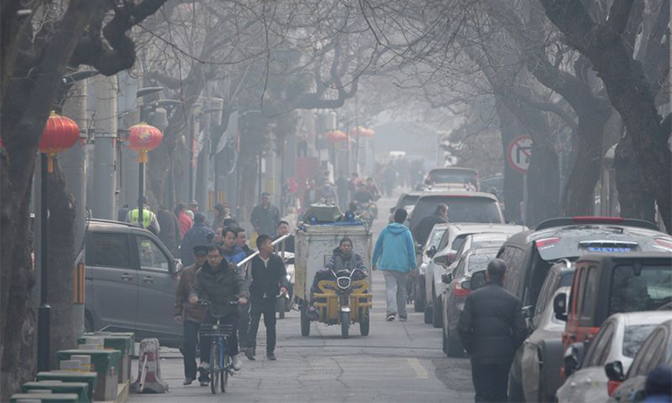 Người dân đi lại trong làn khói mù ô nhiễm tại một phố cổ ở Bắc Kinh ngày 2/3/2019. Ảnh: Reuters.