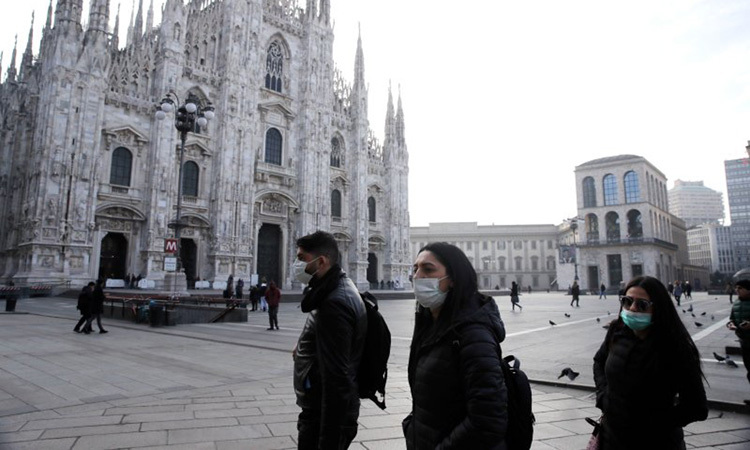 Người dân đeo khẩu trang khi đi qua nhà thờ Duomo ở thành phố Milan, miền bắc Italy hôm 23/2. Ảnh: AP.