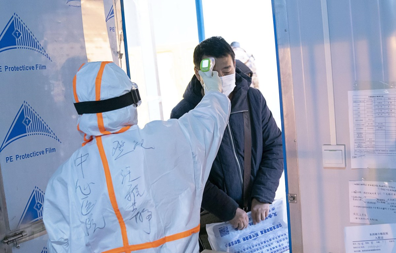 Nhân viên y tế kiểm tra thân nhiệt của bệnh nhân nhiễm COVID-19 tại bệnh viện dã chiến ở Vũ Hán, tỉnh Hồ Bắc, Trung Quốc. (Ảnh: THX/TTXVN)