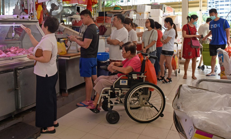 Dân Singapore xếp hàng tại một cửa hàng thịt hôm 22/3. Ảnh: AFP.