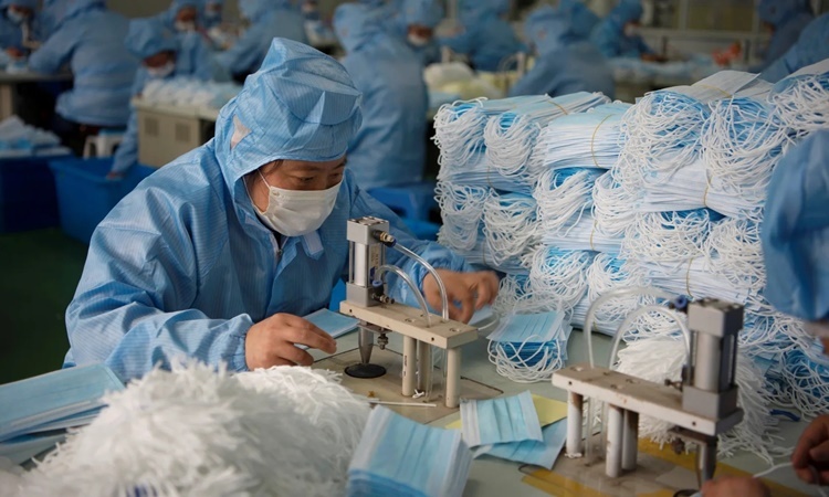 Công nhân làm việc trong một dây chuyền sản xuất khẩu trang ở thành phố Nam Thông, tỉnh Giang Tô, Trung Quốc. Ảnh: Reuters.