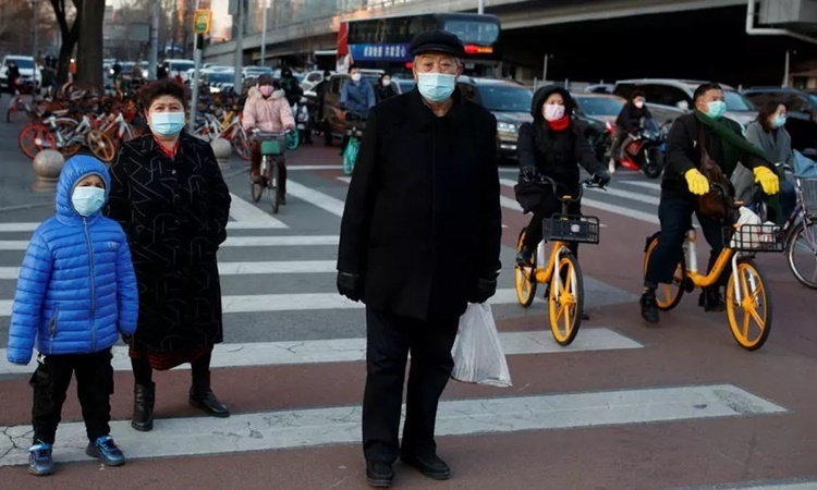 Người dân đeo khẩu trang trên đường phố Bắc Kinh ngày 3/3. Ảnh: AFP.