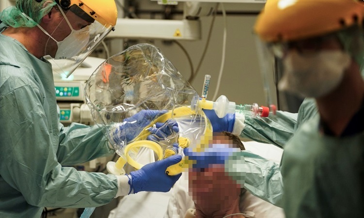 Nhân viên y tế điều trị cho bệnh nhân Covid-19 tại một bệnh viện Erasme ở Brussels, Bỉ hôm 27/3. ẢNh: AFP.
