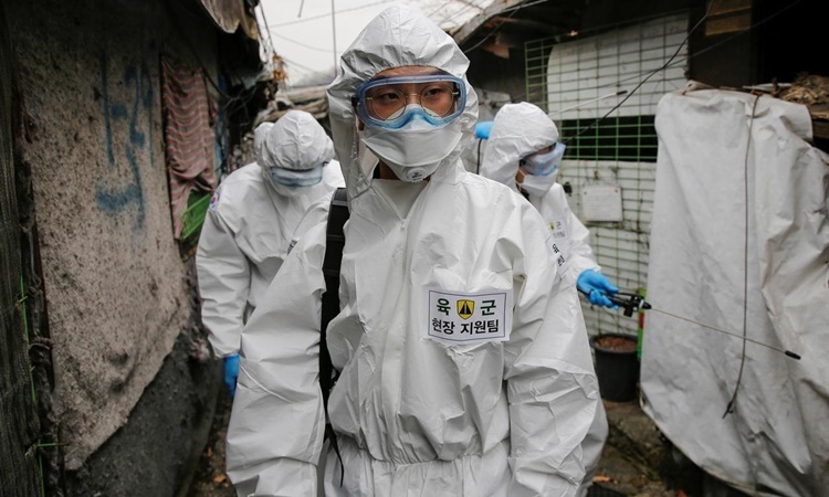 Nhân viên y tế tẩy trùng một khu dân cư ở Seoul, Hàn Quốc, ngày 3/3. Ảnh: Reuters.