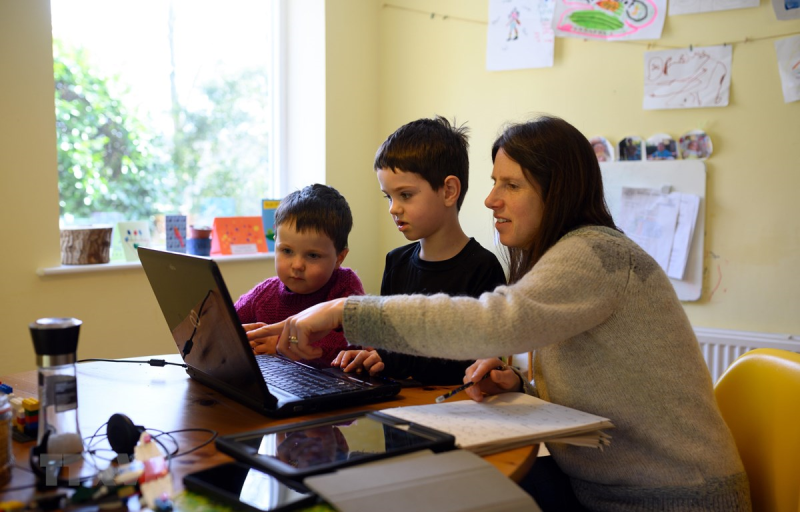 Một gia đình ở Anh giúp con học trực tuyến do các trường học phải đóng cửa vì dịch COVID-19. (Ảnh: AFP/TTXVN)