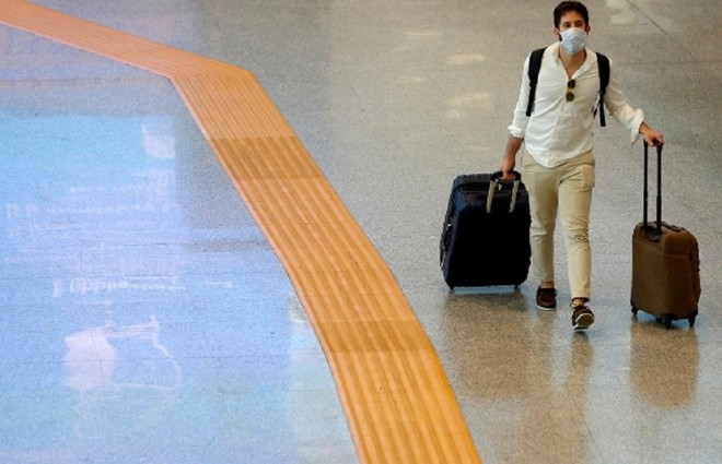 Một hành khách đeo khẩu trang đi bộ tại sân bay Fiumicino, Ý ngày 28.5 /// Reuters