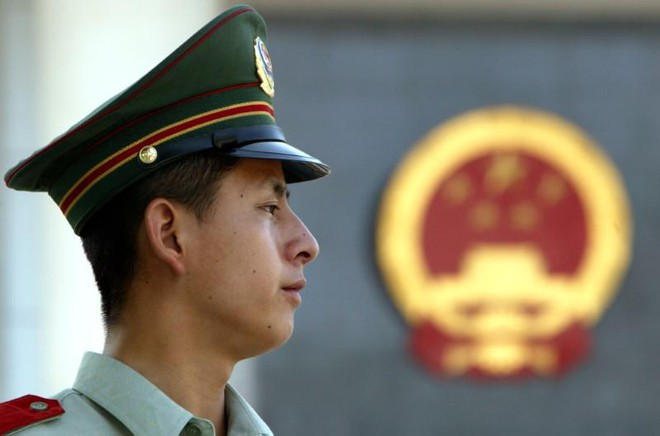 Một cảnh sát Trung Quốc đứng trước tòa án ở Bắc Kinh /// Reuters