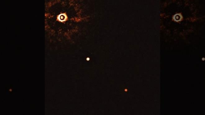 Hình ảnh cho thấy ngôi sao TYC 8998-760-1 (trái) với hai ngoại hành tinh khổng lồ.