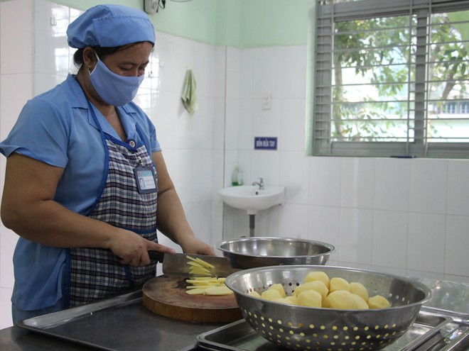Nhân viên nhà bếp ở Trường mầm non Trúc Đào chế biến suất ăn cho trẻ /// NGUYỄN LOAN