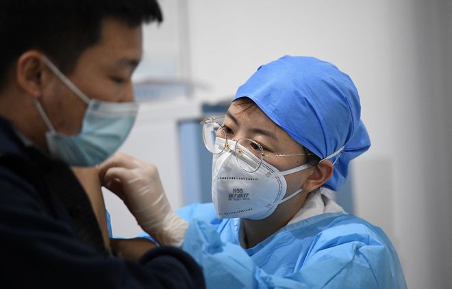 Nhân viên y tế tiêm vắc xin Covid-19 cho một người dân ở thủ đô Bắc Kinh, Trung Quốc /// AFP
