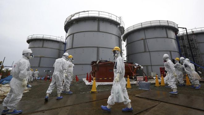 Các công nhân đi ngang qua khu vực đặt bồn chứa nước nhiễm phóng xạ tại nhà máy điện hạt nhân Fukushima Daiichi