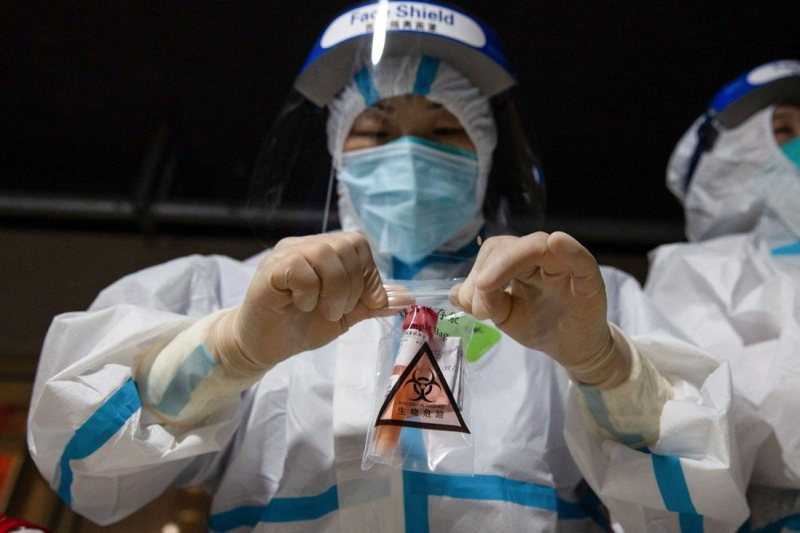 Một nhân viên y tế lấy mẫu xét nghiệm Covid-19 ở  thành phố Nam Kinh /// AFP