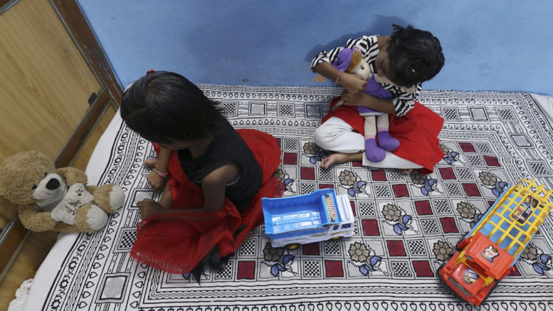 Hai chị em sinh đôi người Ấn Độ Tripti và Pari tại nhà một người họ hàng sau khi mất cả cha lẫn mẹ trong đại dịch /// AFP