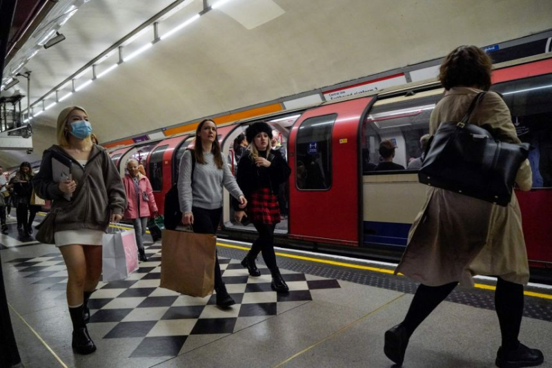 Những người đi làm, một số người đeo khẩu trang, đi dọc theo sân ga sau khi ra khỏi tàu điện ngầm Transport for London ở trung tâm London vào ngày 19 tháng 10 năm 2021. ẢNH: AFP