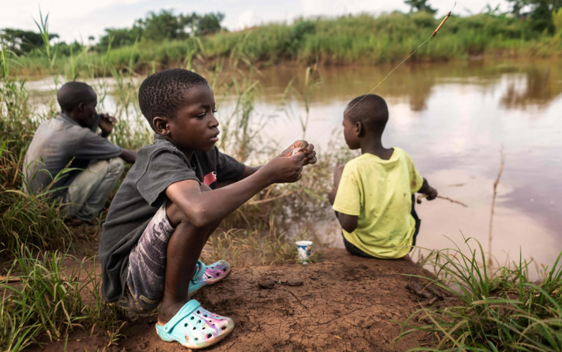 Hai bé trai câu cá trên một con sông gần thành phố Lilongwe, miền trung Malawi – khu vực đang bị ảnh hưởng nghiêm trọng bởi dịch tả. (Ảnh: AFP)